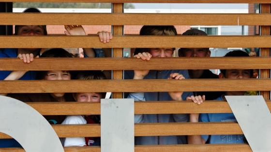 foto kinderen van Kleuterschool De Polyglot achter een houten hek