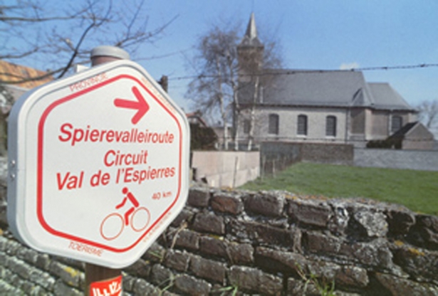 Ziehier een klein bordje met de route van de spierenvalleiroute en met op de achtergrond de Sint-Jan-Baptistkerk 